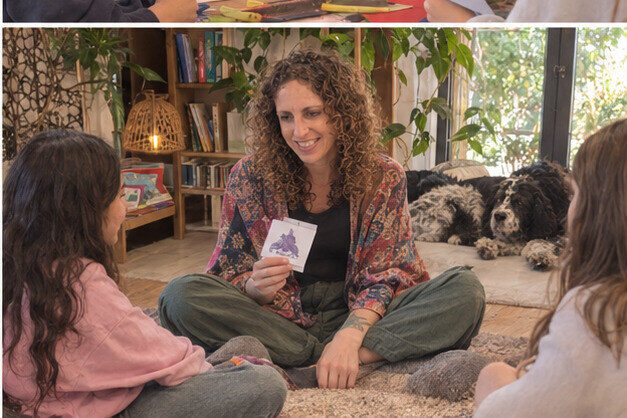 Nicole sitting with children on a rug during a relaxed English picture card activity